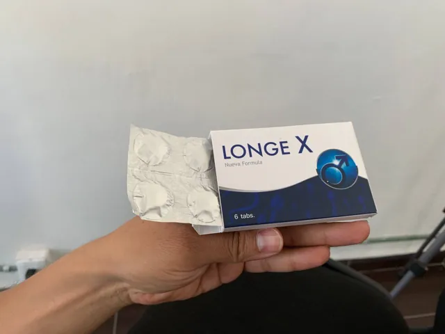 Caja de Longe X abierta con el blíster, sostenida en la mano